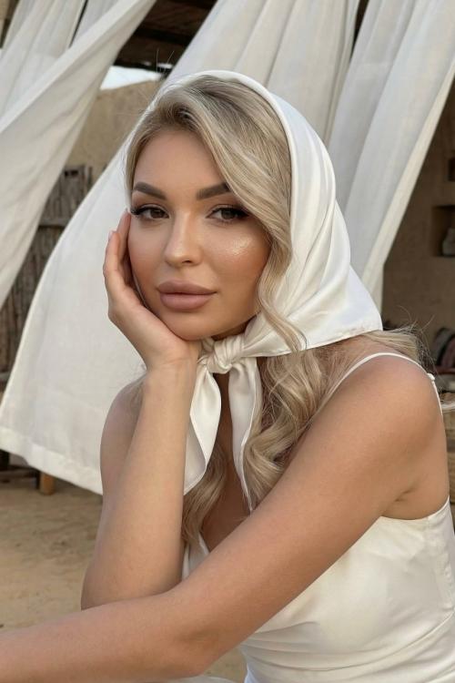 Создайте гламурный портрет молодой женщины до талии (то же лицо, черты лица сохранены) на фоне кафе в пустыне с летящими шелковыми тканями.  